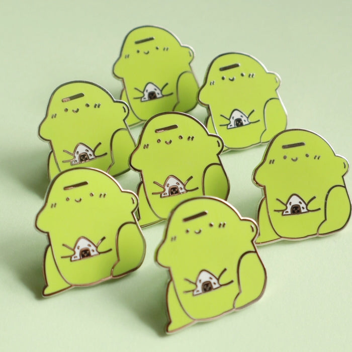 blob frog enamel pin holding rice ball