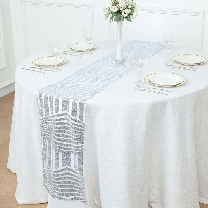 Elegant silver and white table runner on a dining table setting.