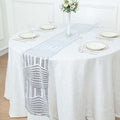 Elegant silver and white table runner on a dining table setting.
