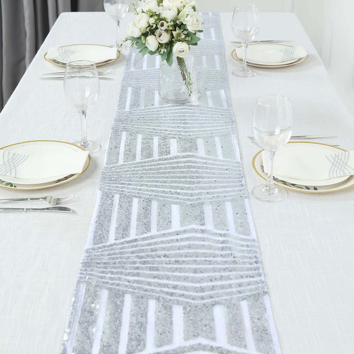 Silver geometric table runner on a dining table with elegant place settings.