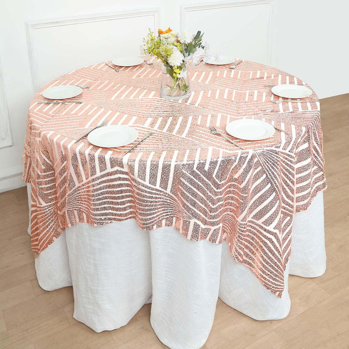 Round table with a patterned tablecloth and white plates set for dining.